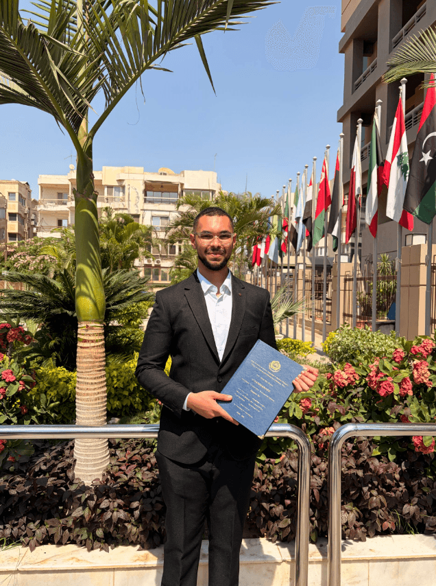 Mohamed Adel Mahmoud holding his graduation certificate at AASTMT.